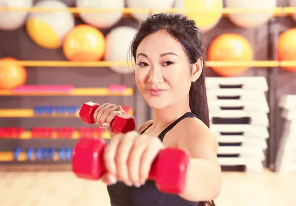 Mujer posando con mancuernas en el gimnasio — Foto de Stock