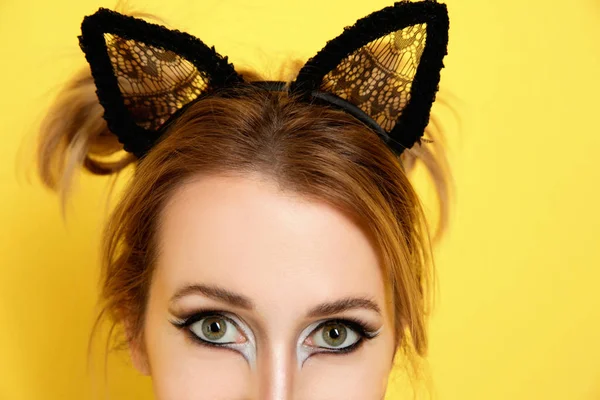 Belle jeune femme avec maquillage de chat et oreilles sur fond de couleur, gros plan — Photo