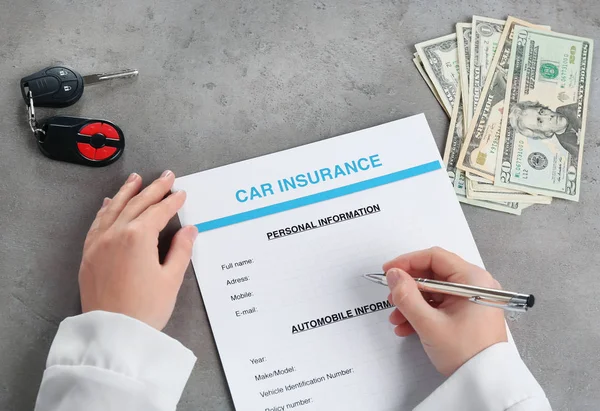 Hand filling in car insurance form — Stock Photo, Image