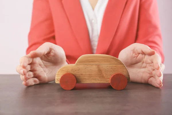 Manos femeninas y coche de juguete de madera — Foto de Stock