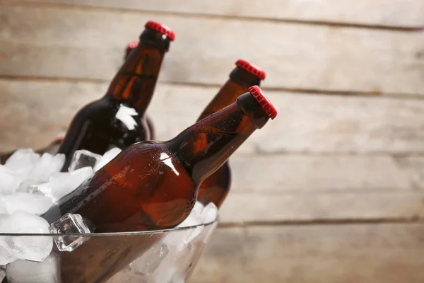 Tigela com garrafas de cerveja no gelo — Fotografia de Stock