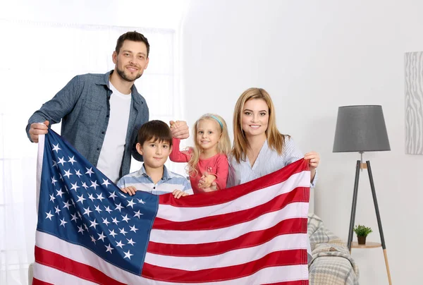 Famille heureuse avec drapeau américain à la maison — Photo