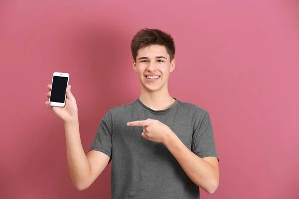 Adolescente con teléfono móvil sobre fondo de color —  Fotos de Stock