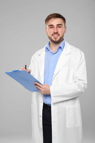 Beau médecin avec presse-papiers bleu — Photo