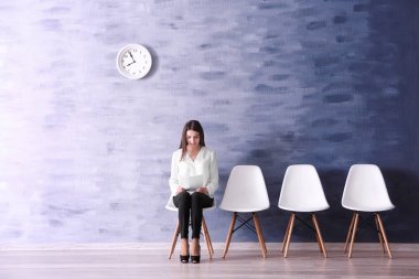 Resepsiyon salonunda iş görüşmesi için bekleyen genç kadın
