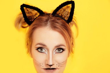 Güzel genç kadın kedi makyaj ve renk arka plan üzerinde kulakları ile