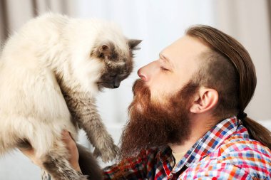 Genç adam ile kabarık kedi evde sakallı
