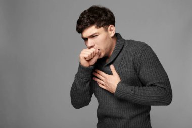 Gri arka plan üzerinde genç hasta adam