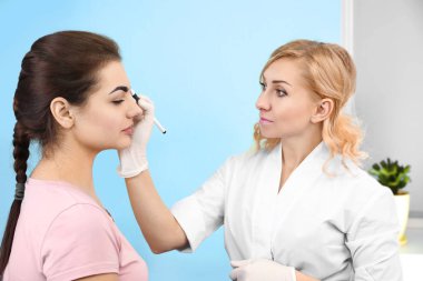 Genç güzel kadın kozmetik salonda kalıcı makyaj yapma