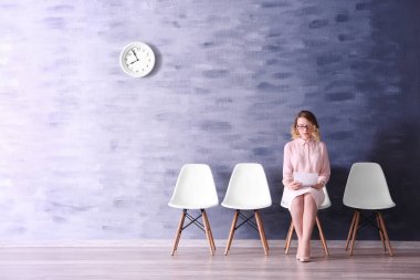 Resepsiyon salonunda iş görüşmesi için bekleyen genç kadın