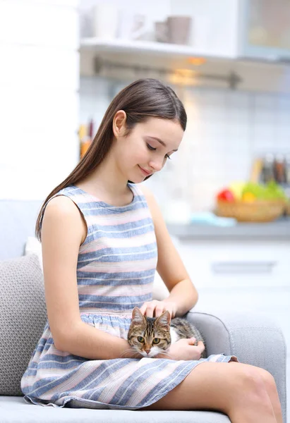 Piękna młoda kobieta z uroczym kotem w domu — Zdjęcie stockowe