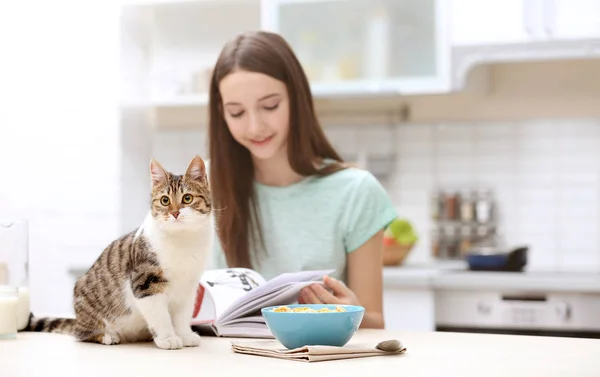 Mañana de hermosa joven y gato en la cocina — Foto de Stock