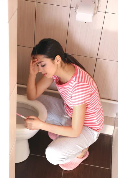 Mladá žena zvracení u záchodové mísy doma — Stock fotografie