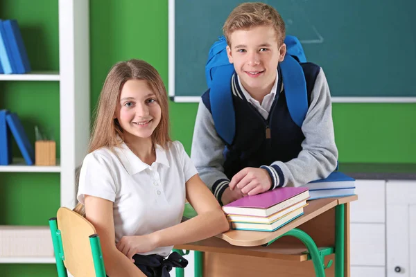 Teenagers with books in classroom — Stock Photo, Image