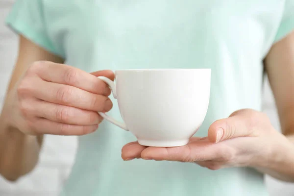 White cup in hands — Stock Photo, Image