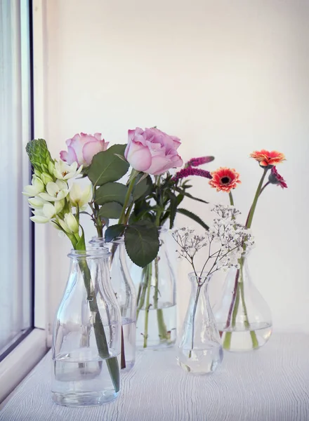 Jarrones de vidrio con hermosos ramos de flores — Foto de Stock