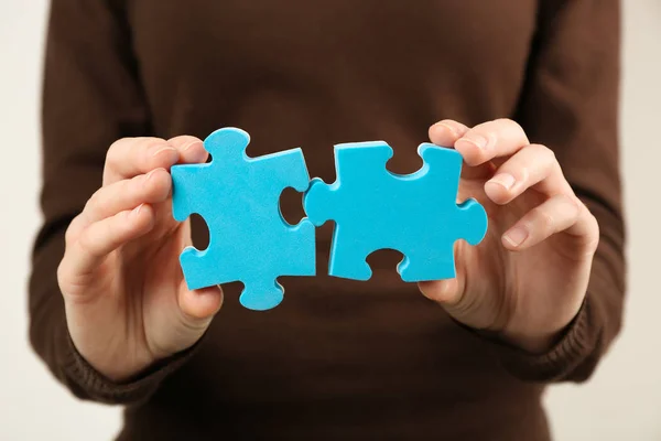 Dvě puzzle v ženských rukou — Stock fotografie