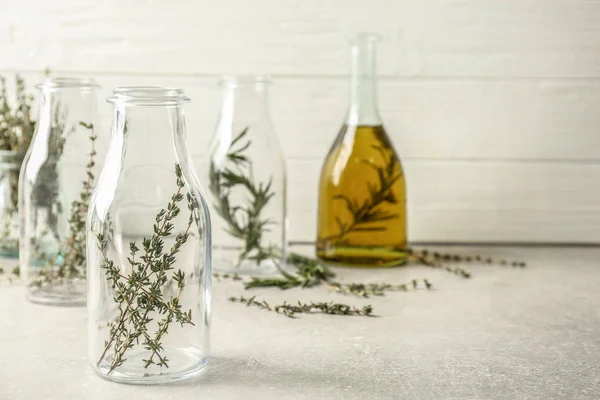 Bottles with thyme on table — Stock Photo, Image