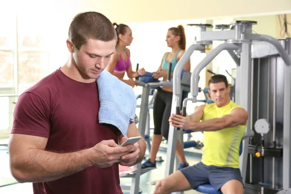 年轻英俊的男人 用手机在健身房 — 图库照片