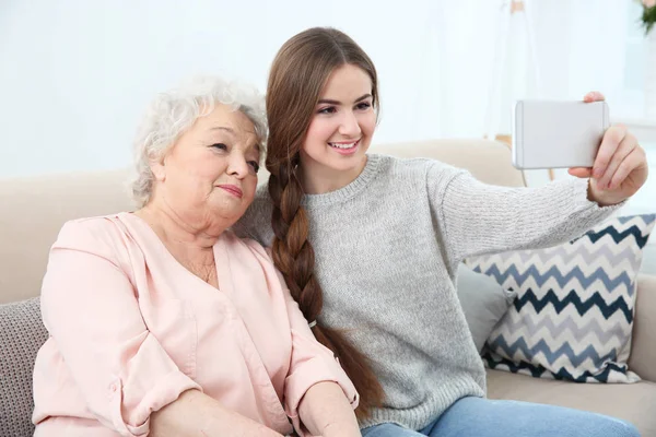 집에서 소파에 selfie를 복용 하는 할머니와 함께 아름 다운 소녀 — 스톡 사진