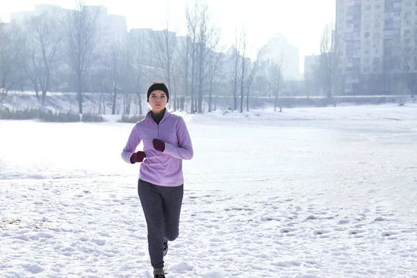 Молодая женщина бежит зимой — стоковое фото