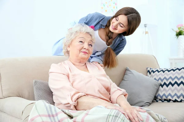 Hermosa chica peinando el pelo de la abuela en casa — Foto de Stock