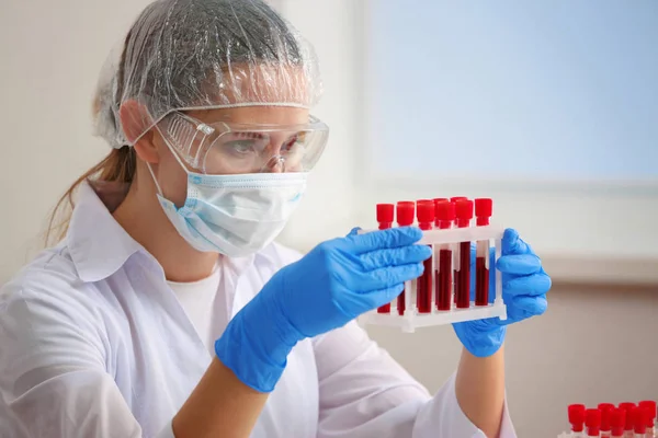 Mujer que trabaja con muestras de sangre en laboratorio —  Fotos de Stock