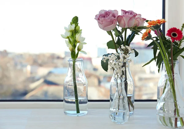 Стеклянные вазы с красивыми букетами цветов — стоковое фото