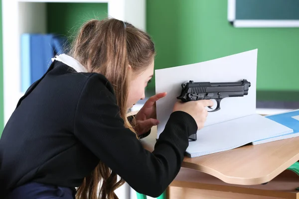十几岁的女孩在教室里从枪瞄准 — 图库照片