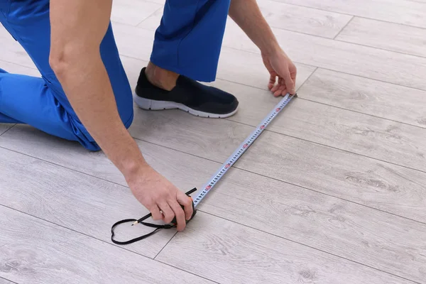 Homem instalando novo piso laminado de madeira — Fotografia de Stock