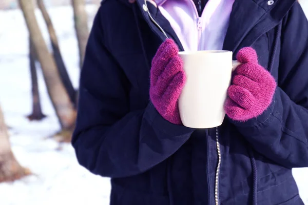 hands in pink gloves holding cup