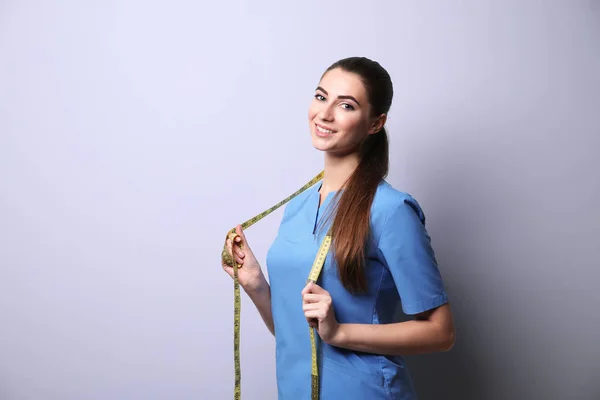 Jonge vrouwelijke voedingsdeskundige op lichte kleur achtergrond — Stockfoto