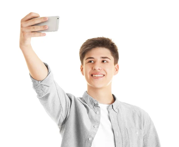 Adolescente haciendo selfie con teléfono móvil sobre fondo blanco —  Fotos de Stock