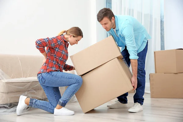 Vrouw die lijden aan pijn terwijl het Verhuisdozen op kamer — Stockfoto