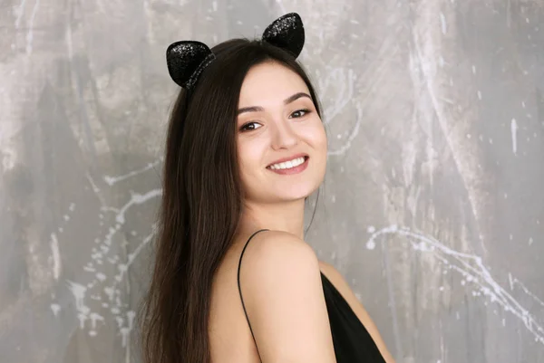 Красивая молодая женщина с кошачьими ушами на фоне гранжа — стоковое фото