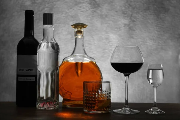 Διαφορετικά μπουκάλια κρασιού και οινοπνευματωδών ποτών σε χρώμα φόντου — Φωτογραφία Αρχείου
