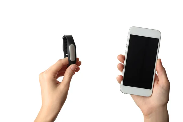 Ženské ruce s fitness tracker a chytrý telefon na bílém pozadí — Stock fotografie