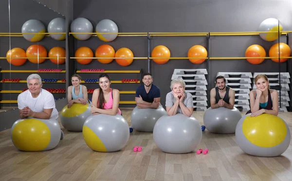 Pessoas de diferentes idades treinando com bolas em forma no ginásio — Fotografia de Stock