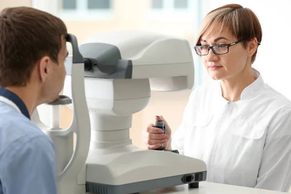 Oftalmólogo midiendo la presión intraocular del joven en la clínica — Foto de Stock