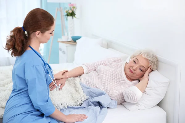 Pielęgniarka, rozmowy ze starszą kobietę w pokoju światło — Zdjęcie stockowe