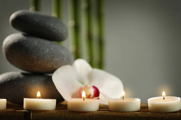 Seixos e velas com flor de orquídea — Fotografia de Stock