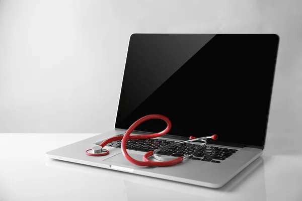 Modern laptop and stethoscope — Stock Photo, Image