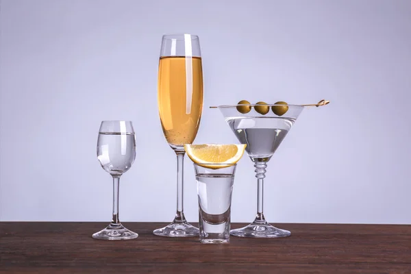 Mesa con copas de vino y licores sobre fondo de color — Foto de Stock