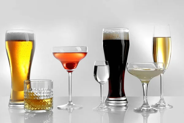 Okulary, wina i napojów spirytusowych na jasnym tle — Zdjęcie stockowe