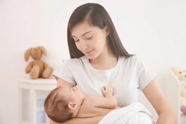 Mãe feliz com bebê pequeno bonito em casa — Fotografia de Stock