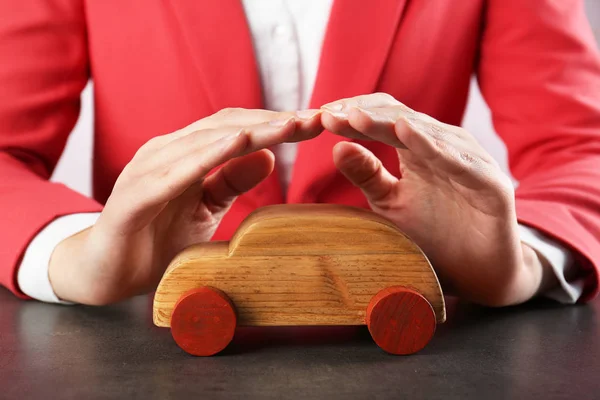 Женские руки и деревянная игрушечная машина — стоковое фото
