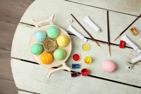 Paints and brushes with Easter eggs — Stock Photo, Image