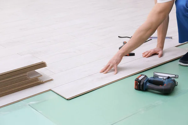 Homem instalando novo piso laminado de madeira — Fotografia de Stock