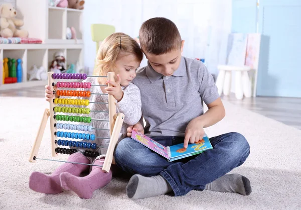 Broer en zus spelen met de abacus — Stockfoto