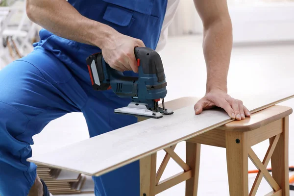 Man cutting laminate board with jigsaw — Stock Image Man cutting laminate board with jigsaw Royalty Free Stock Images